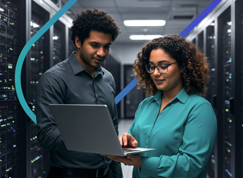 Dois profissionais de TI em um data center analisam configurações de servidores em um laptop. A imagem ilustra a colaboração em tarefas de infraestrutura e segurança, focando na otimização de sistemas digitais.